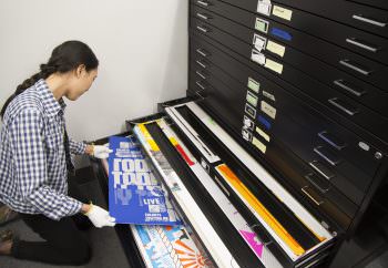 MFA student Christina Huang sorting posters in the archive.
